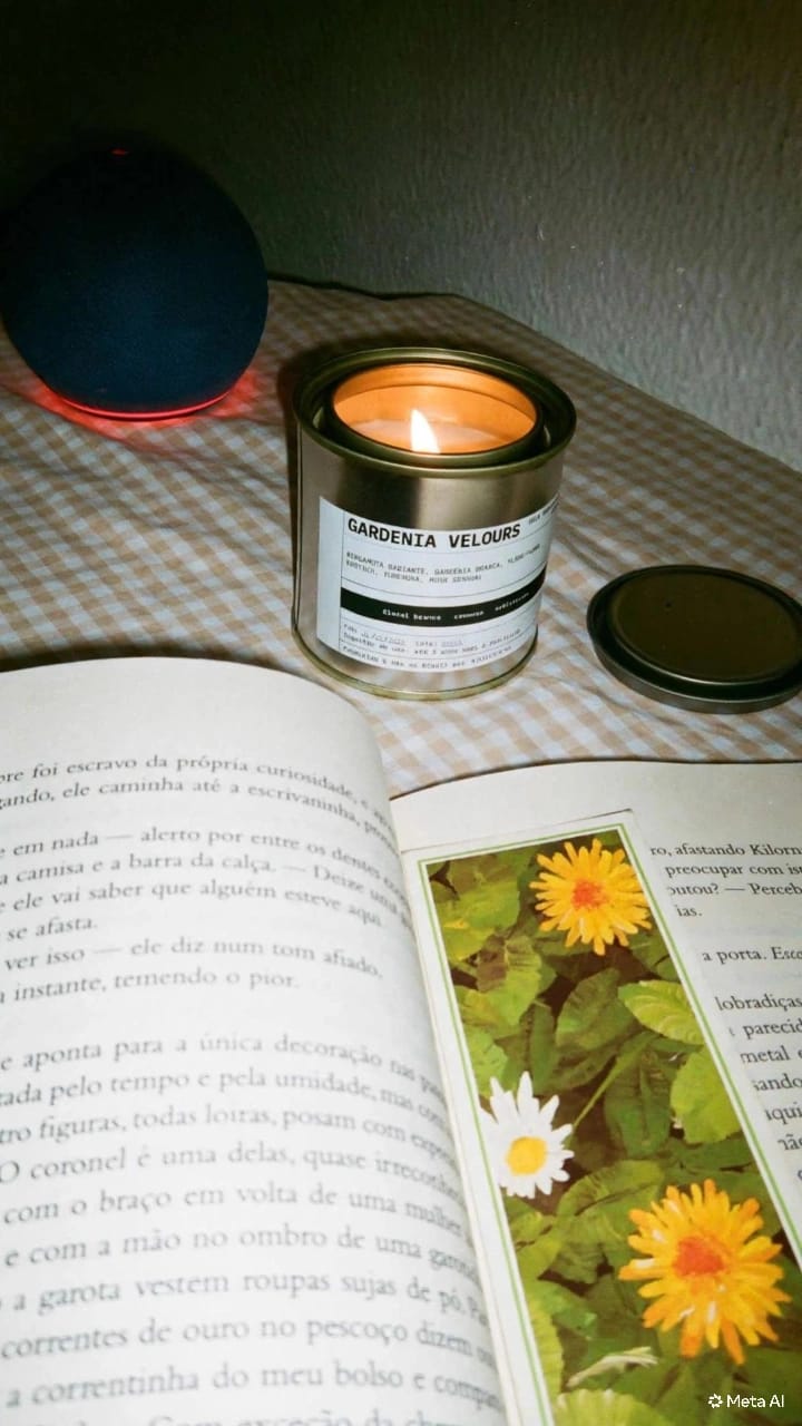Gardenia Velours acesa ao lado de um livro aberto